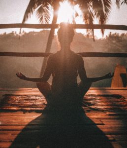 An image featuring a woman meditating in the sunlight